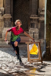 Woman punching at control point, taking part in orienteering city race competitions in old european city. File contains clipping path